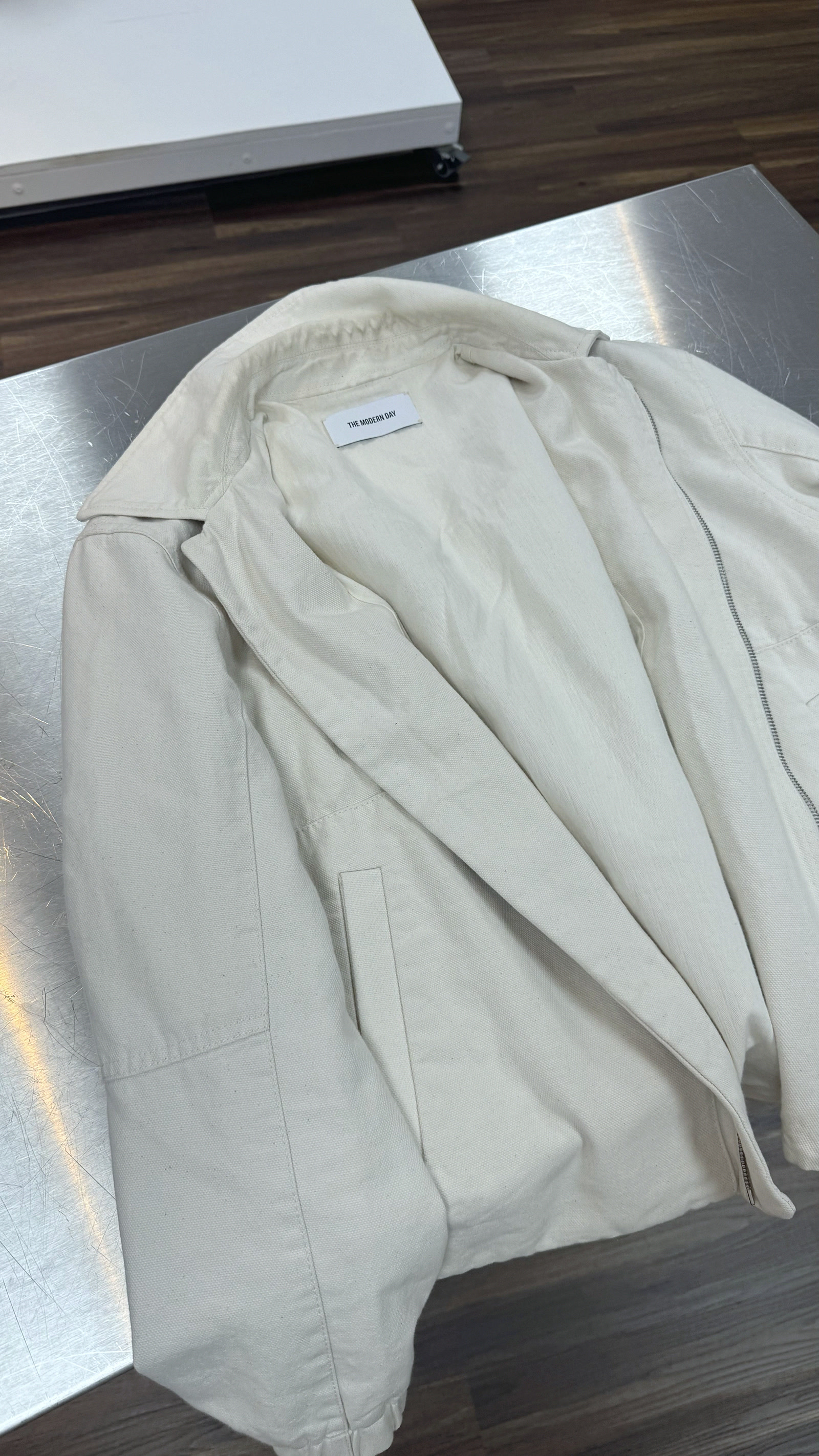 THE MODERN DAY cotton workers jacket, laid full on a steel table